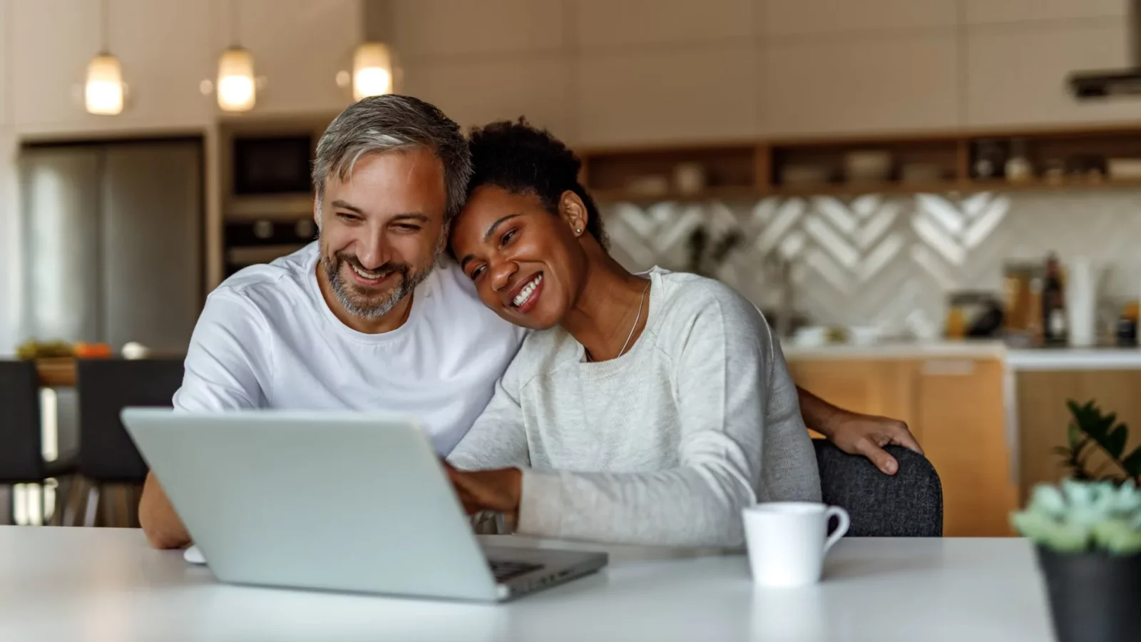 a man and woman smiling while using a laptop at The Lofts at Allen Ridge